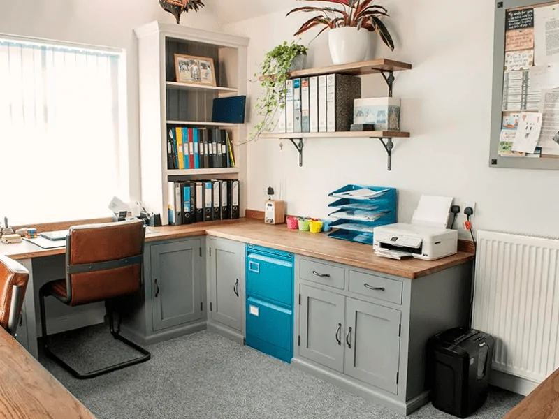 Home office, with chair facing a window and a blue cupboard on the wall