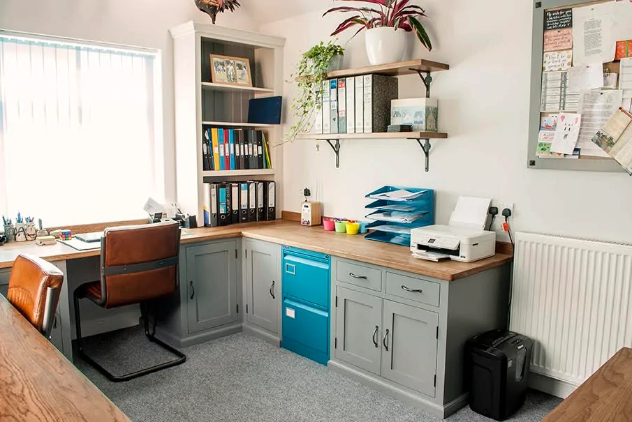 Home office, with chair facing a window and a blue cupboard on the wall