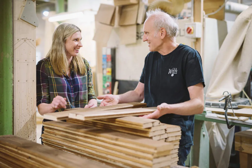 Woman speaking to a joiner in the workshop