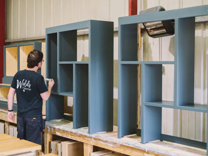 Man painting shelves blue