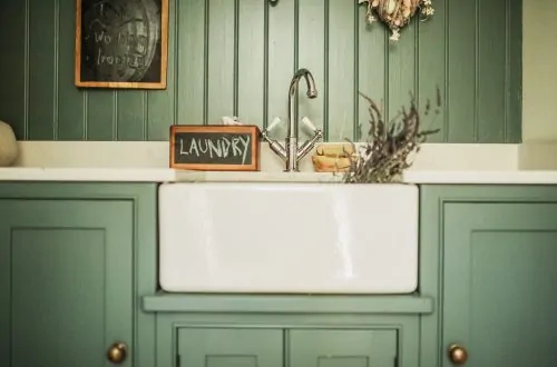 Belfast sink in laundry room with a chalk board with the word laundry written on it